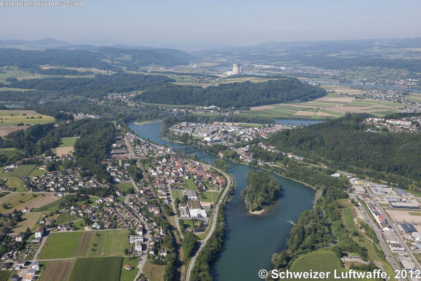 Koblenz mit Rheininsel 'Grindli'. Bildhintergrund: Kernkraftwerk Leibstadt. Rechts unten im Bild: Industrie- und Gewerbezone Tiengen-Waldshut. Auf der Waldlichtung: Waldshut - Bergstadt.